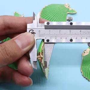 Mesure macro de l'épaisseur de 8,8 mm du pendentif coquillage vert au bord doré