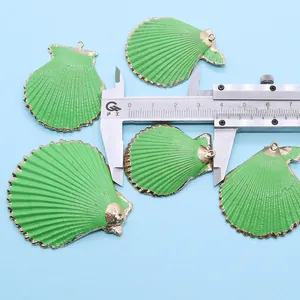 Vue détaillée de cinq pendentifs coquilles Saint-Jacques verts avec bords dorés et règle