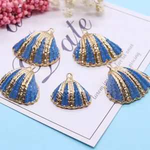 Natural scallop shell pendants in blue and gold stripes with metallic hanging loops
