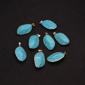 Macro-detail van turquoise hangers in bladvorm met goud en zilver vergulde metalen rand