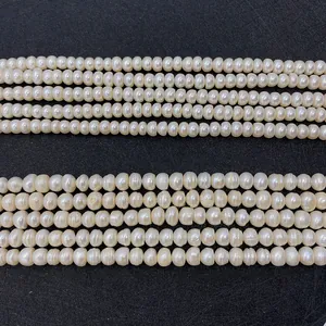 Macro view of natural white freshwater pearl strands showing texture and soft luster on black background