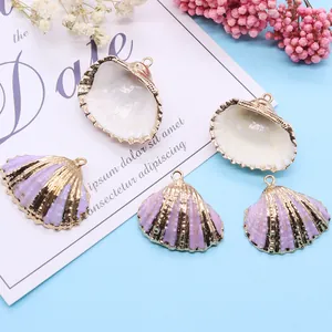 Paarse schelphangers met gouden randen op blauwe achtergrond voor doe-het-zelf sieraden