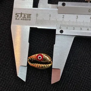 Detailed measurement of golden shell bead with red evil eye design showing 1.6cm size
