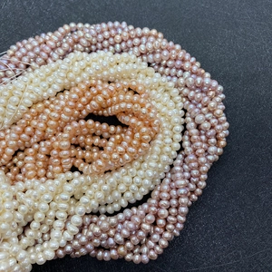 Nahaufnahme natürlicher 3-5mm Süßwasserperlen in den Farben Weiß, Rosa und Violett