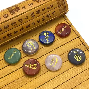 Set of 7 natural gemstone Reiki chakra stones with gold symbols on a bamboo mat