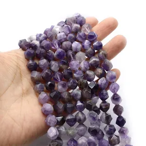 Faceted natural purple amethyst beads for DIY jewelry making held by hand on white background