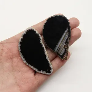Dettaglio macro di due fette di agata naturale nera per la creazione di collane DIY