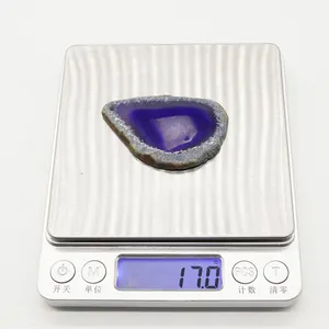 Dettaglio macro di un ciondolo in agata viola con cristalli naturali su una bilancia