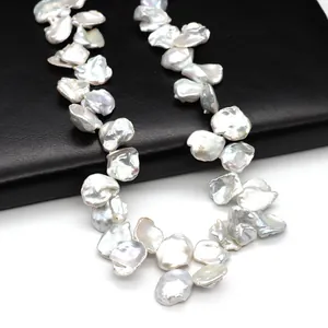 Natural Baroque petal pearl necklace with intense metallic luster on black leather surface
