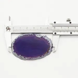 Misurazione di un ciondolo in agata viola con un calibro digitale su sfondo bianco puro