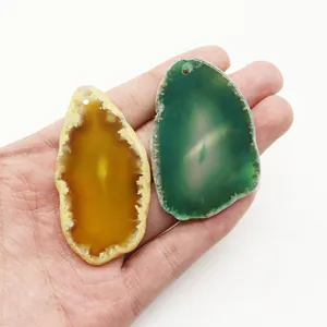 Pendenti in pietra d'agata naturale gialla e verde mostrati sulla mano per misura