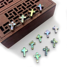 Macro detail of natural abalone shell cross beads with iridescent texture for jewelry making