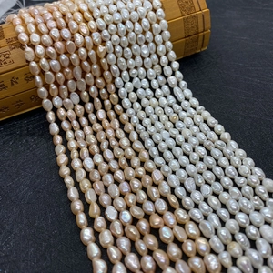 Natural 4-8mm freshwater rice pearls in white and pink displayed on a bamboo mat