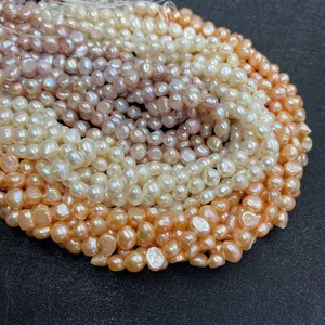 Macro shot of 6-8mm natural freshwater pearls in orange, white and purple on black