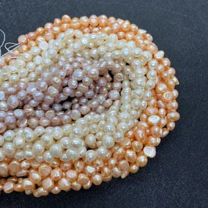 Macro detail of natural freshwater baroque pearls in white, pink, and orange tones