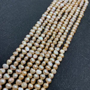 Detalle macro de hilos de perlas barrocas de agua dulce champán para joyería DIY