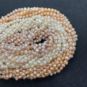 Detailed close-up of natural freshwater pearls in champagne, pink, and white shades