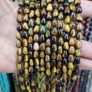 Macro detail of drop-shaped tiger eye stone beads with natural chatoyancy effect