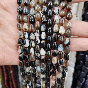 Macro detail of teardrop-shaped natural agate beads with unique eye patterns and textures