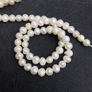 Détail macro de perles d'eau douce blanches naturelles sur fond noir texturé