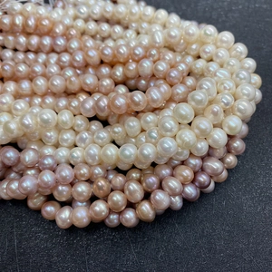 Detailed macro view of natural freshwater pearls in white, pink, and purple shades