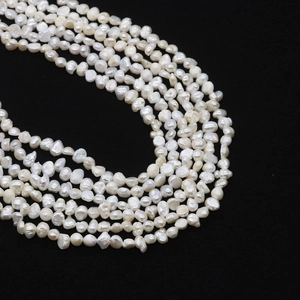 Macro shot of natural baroque freshwater pearls with lustrous white finish on black background