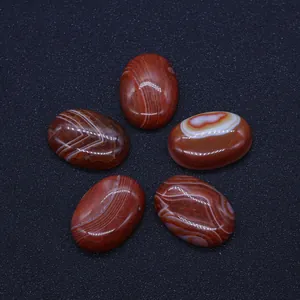 Macro shot of 5 oval red agate cabochons with natural white stripes on black background