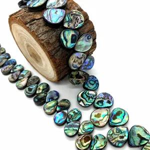 Macro-opname van iriserende abalone schelpkralen in druppelvorm met natuurlijke texturen