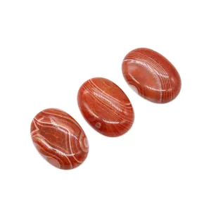 Set of three polished 25x35mm oval red agate stones with natural white striped patterns