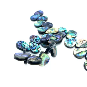 Macro-opname van natuurlijke abalone schelpkralen in druppelvorm met iriserende blauwe glans