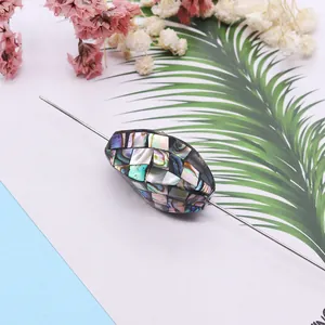 Oval twisted bead crafted from natural abalone shell mosaic with iridescent finish