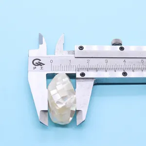 Macro detail of natural abalone shell bead showing 18mm size with a vernier caliper