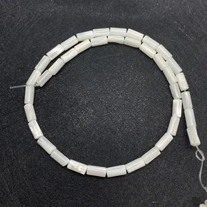 Macro shot of white cylindrical natural shell beads with glossy mother of pearl finish