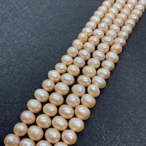 Macro detail of natural peach pink freshwater pearls on black leather background