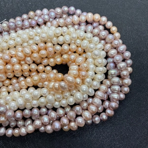 Macro detail of natural freshwater pearls in white, pink, and purple colors for DIY jewelry