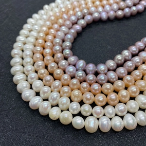 Natural freshwater pearl necklace strands in white pink and purple colors on black background