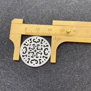 Vue détaillée d'un pendentif en nacre de 25mm avec motif de sculpture évidée précis