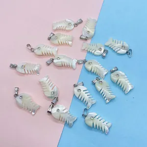 Macro shot of fishbone-shaped natural shell pendants with rhinestones for DIY necklaces