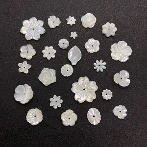 Macro detail of white shell flower beads in rose and daisy shapes for DIY jewelry making