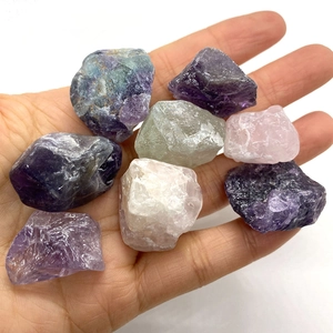 Vue rapprochée de pierres brutes d'améthyste et quartz rose tenues dans la main