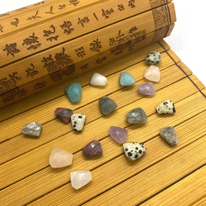 Faceted natural stone beads including amethyst and amazonite on bamboo mat background