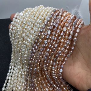 Macro view of natural freshwater pearls in white, lavender, and pink on hand for DIY