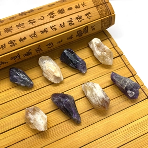 Piliers naturels de cristal d'améthyste et de citrine présentés sur un tapis en bambou