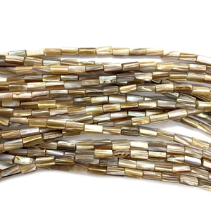 Macro shot of 5x8mm natural shell tube beads with brown and amber pearlescent texture