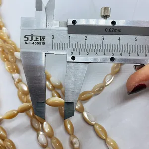 Detailansicht natürlicher Muschelperlen mit Messschieber zeigt die 15mm Perlenlänge