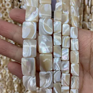 Makroaufnahme von rechteckigen Perlmuttschalenperlen mit irisierendem Glanz in Creme