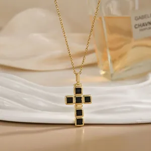 Collier croix dorée avec pierres de zircon noir carrées sur plateau texturé