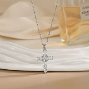 Détail macro d'un pendentif croix en cristaux facettés sur une chaîne en argent