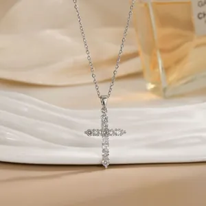 Détail d'un pendentif croix en argent avec zircons sur une fine chaîne élégante