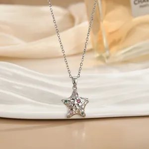 Collana a pentagramma in argento con zirconi colorati su un piatto di porcellana bianca